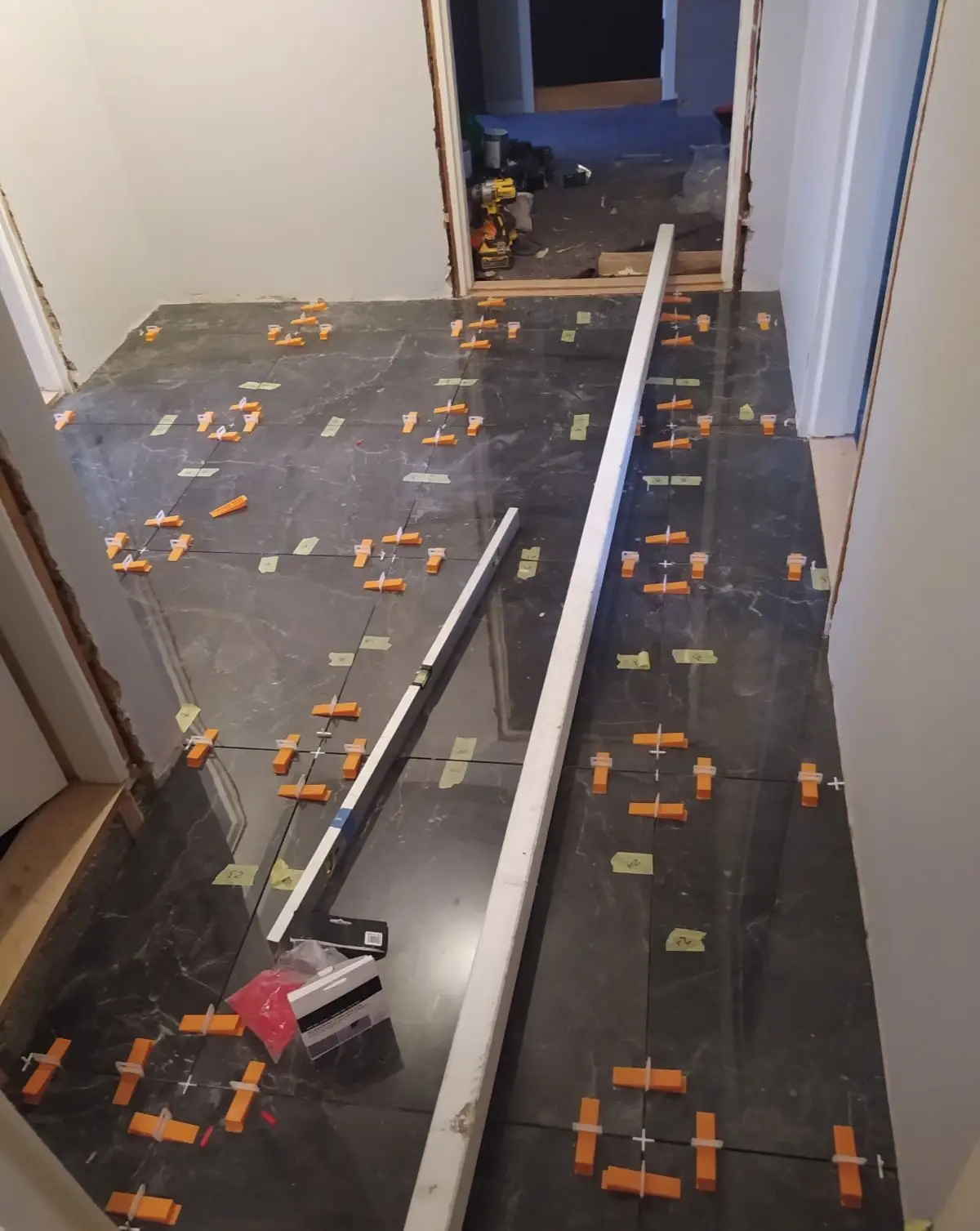 Tiler in Oslo laying dark tiles with spacers and levelling clips