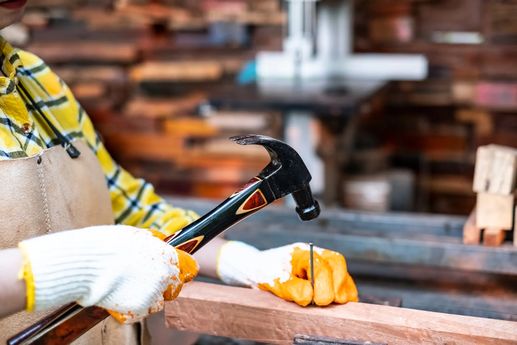 Carpenter at work with hammer and timber